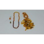 A collection of antique amber necklaces and beads, including two odd amber and silver earrings, a
