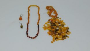 A collection of antique amber necklaces and beads, including two odd amber and silver earrings, a