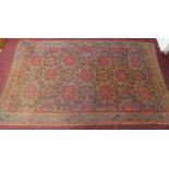 A Persian rug with repeating multicolour diamond motifs surrounded by repeating geometric borders