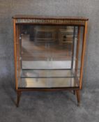 A 1960's vintage display cabinet with a faux rosewood top, fitted glass shelves on dansette legs.