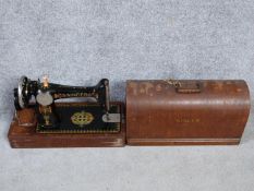 An antique oak cased Singer sewing machine with key, instruction booklet and multiple sewing machine