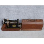 An antique oak cased Singer sewing machine with key, instruction booklet and multiple sewing machine