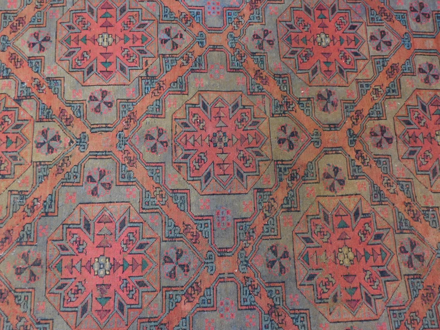 A Persian rug with repeating multicolour diamond motifs surrounded by repeating geometric borders - Image 2 of 6