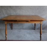 A Continental teak extending dining table on turned supports. H.74 W.224 D.91cm (fully extended).
