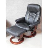 A black leather upholstered 'Stressless' Ekornes adjustable revolving armchair with matching