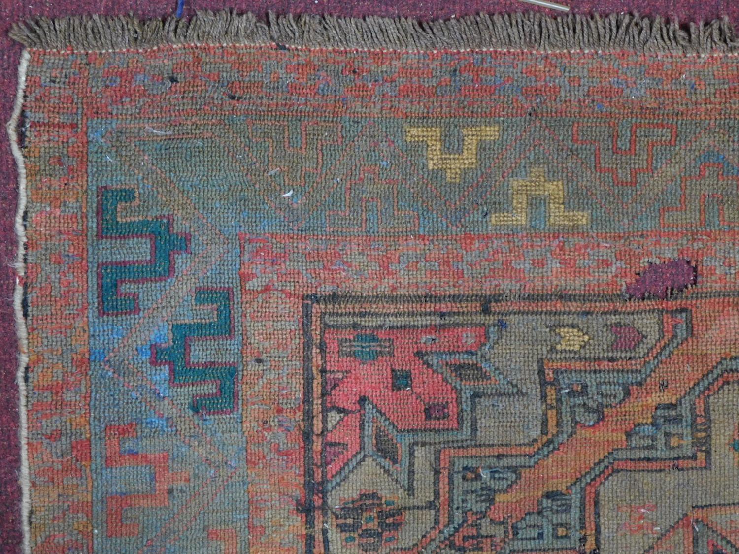 A Persian rug with repeating multicolour diamond motifs surrounded by repeating geometric borders - Image 3 of 6