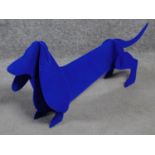 A metal fabric covered dog sculpture by British artist Peter Clark of a sausage dog with blue