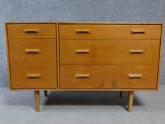 A 1970's vintage teak chest of three graduating long drawers flanked by three short drawers raised