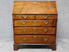 A Georgian mahogany bureau with fitted interior above two short over three long graduating drawers