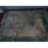A large Chinese rug with allover bird and flower motifs and spandrels on a mink field encompassed by