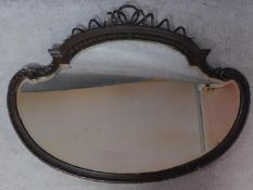 A shaped bevelled plate wall mirror with Regency style ribbon cresting. 87x113cm
