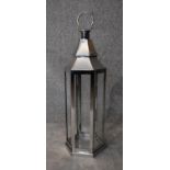 A tall metal framed storm lantern. H.88cm