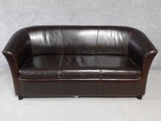 A tan leather two seater tub shaped sofa. H.78 W.173 D.83cm