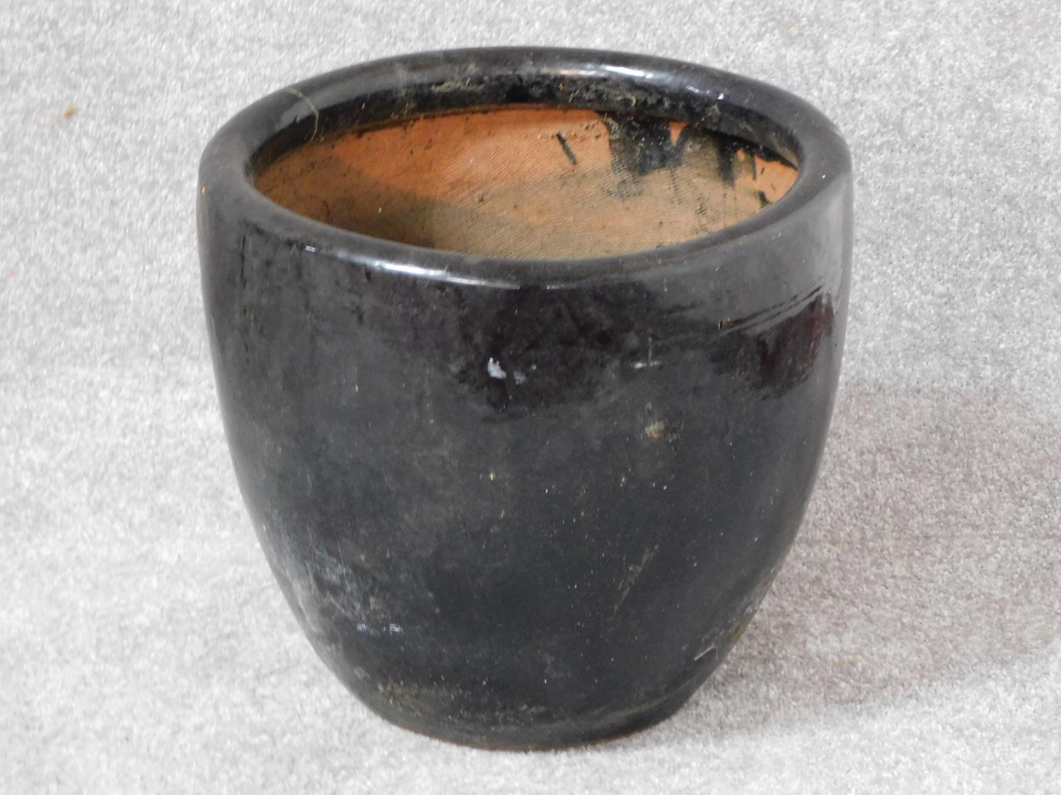 A terracotta black glazed garden planter. H.33 W.36 D.36cm