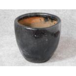 A terracotta black glazed garden planter. H.33 W.36 D.36cm