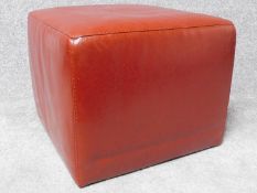 A red leather cubiform footstool. H.42 W.52 D.52cm