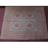 An Engsi style symmetrical rug on an ivory and rouge field surrounded by multiple geometric