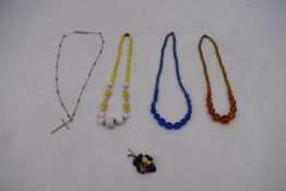 A collection of vintage Czech glass necklaces including an opaque yellow and white glass necklace, a