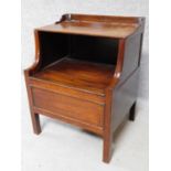 A Georgian mahogany night table with folding shelf and panel enclosing compartment on square