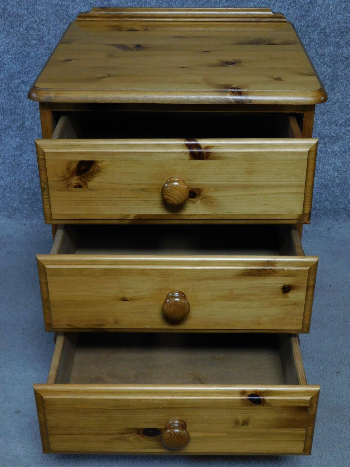 A pair of contemporary pine bedside chests with three drawers on casters, by English maker Victoria. - Image 2 of 5