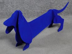 A metal fabric covered dog sculpture by British artist Peter Clark of a sausage dog with blue