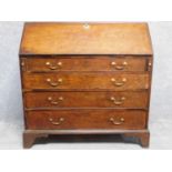 A Georgian mahogany bureau with fall front revealing fitted interior above four graduating drawers