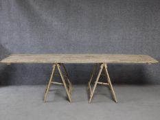 A vintage distressed painted pine trestle table on folding supports. H.270 L.76 W.59cm