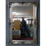 A large silver rococo framed bevelled wall mirror. 183x123cm