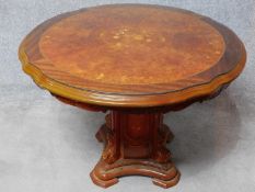 An Italian circular burr walnut dining table with floral inlaid top on carved pedestal base. H.75