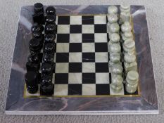 A vintage boxed Turkish carved hardstone chessboard and pieces. The pieces are made from a pale