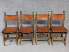 A set of four antique oak dining chairs with tan leather seats and backs on square stretchered