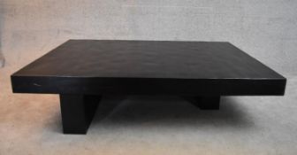 A large contemporary black lacquered coffee table on block supports. H.38x160x110cm