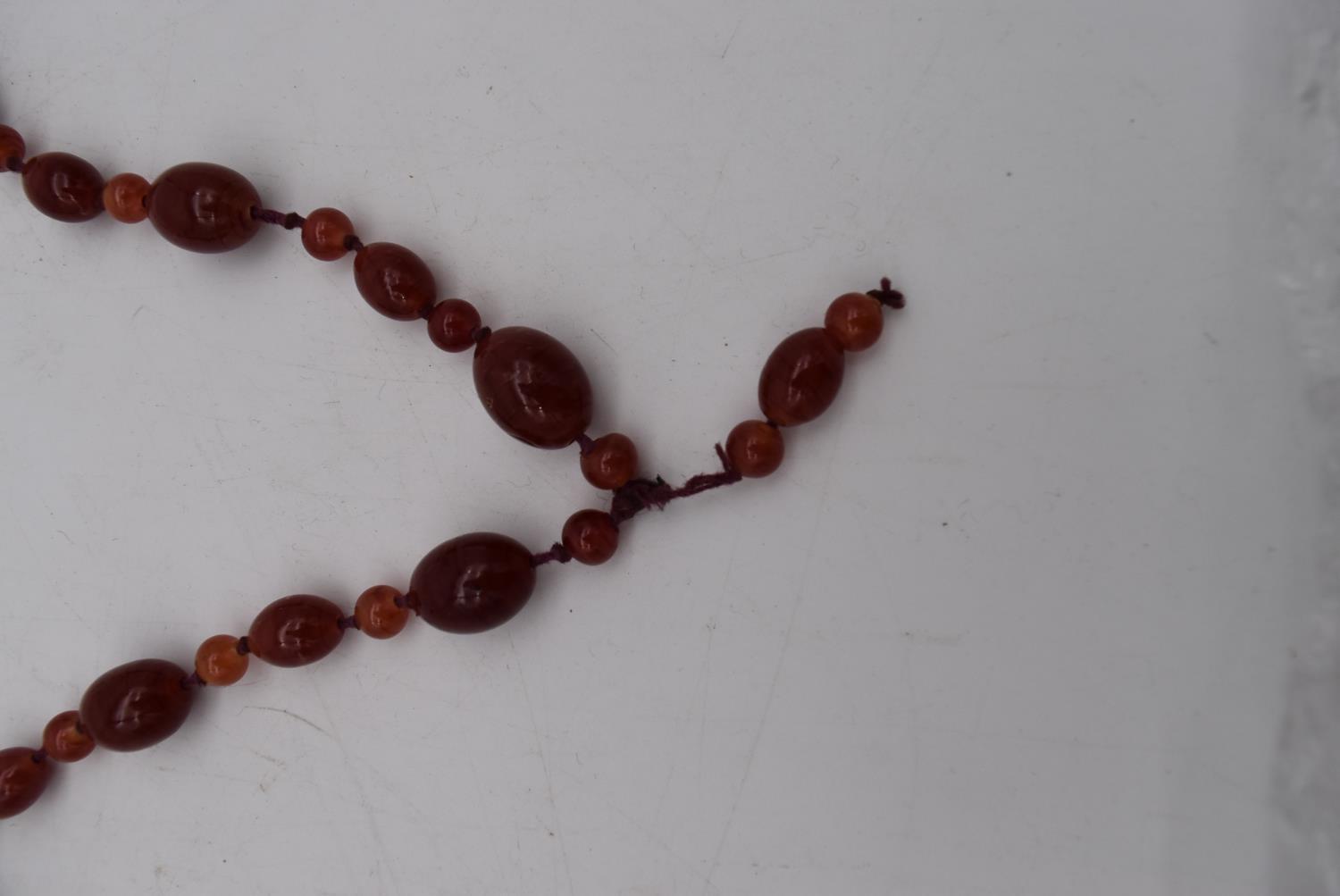 An antique marbled red and orange glass bead knotted necklace. - Image 3 of 3