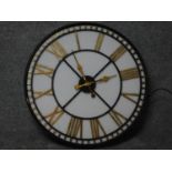 A light up glass fronted shop display clock with gilded roman numerals and movable hands. 80x80cm