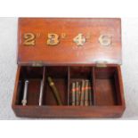An antique oak shop display cigar box with cigars. The box has internal partitions and gilded