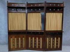 An Arts and Craft's mahogany two fold, three panel screen with folding shelves and curtains. H.157