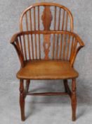 An antique country yew wood Windsor armchair with pierced central splat above elm seat on turned