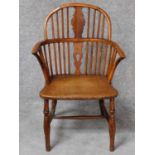 An antique country yew wood Windsor armchair with pierced central splat above elm seat on turned