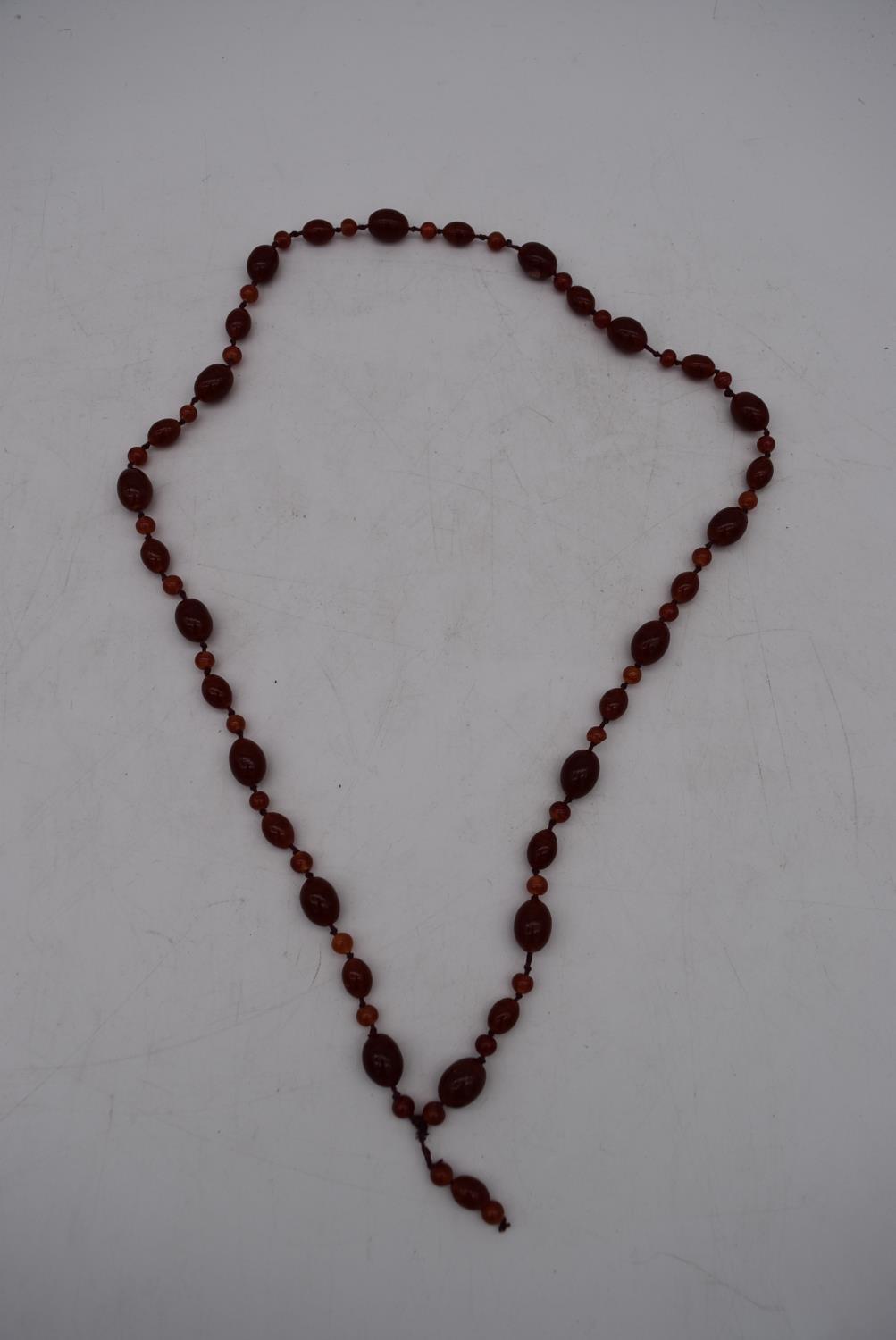 An antique marbled red and orange glass bead knotted necklace.