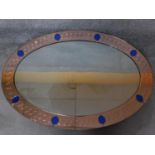 An Art Deco peach glass framed wall mirror with blue glass insets. 128x98cm
