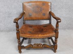 A mid 20th century Jacobean style oak armchair in embossed tan leather upholstery. 65cm