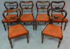 A set of six Victorian rosewood kidney shaped back dining chairs with drop in seats on carved