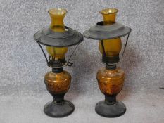 A pair of vintage amber moulded glass and metal oil lamps. Stamped made in Hong Kong to base. H.43cm