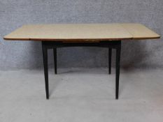 A 1960's vintage draw leaf dining table with Formica top on ebonised supports. H.71 W.150 D.75cm