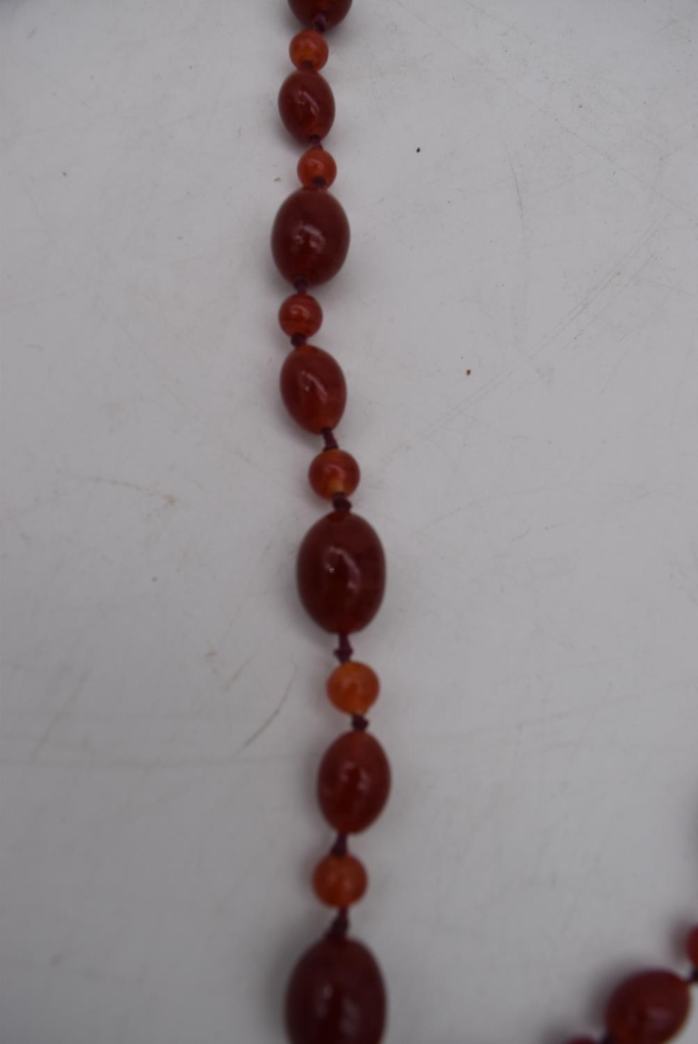 An antique marbled red and orange glass bead knotted necklace. - Image 2 of 3