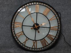 A glass fronted shop display clock with gilded roman numerals, wired and internally lit. 80x80cm