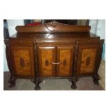 A 1920/30S HEAVY OAK AND WALNUT BOWED SIDEBOARD, DECORATED WITH EASTERN STYLE CARVED HEAD DETAIL,