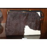 A VINTAGE COW HIDE HANDBAG, with gilt metal fittings and satin lined interior