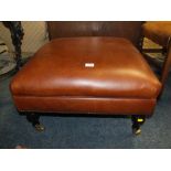 A MODERN UPHOLSTERED BROWN LEATHER FOOTSTOOL