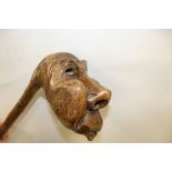 AN UNUSUAL CHARACTER TOPPED CARVED WOODEN WALKING STICK